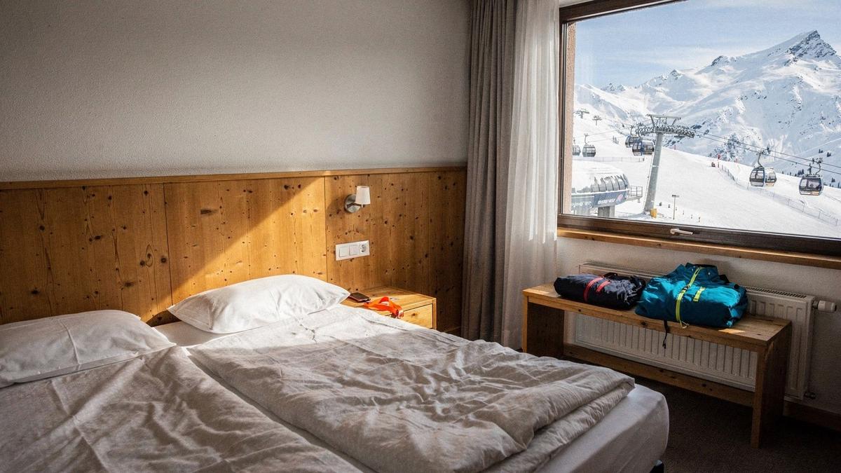 Twin room in a four-star Alpine ski hotel with a window view of snowy slopes